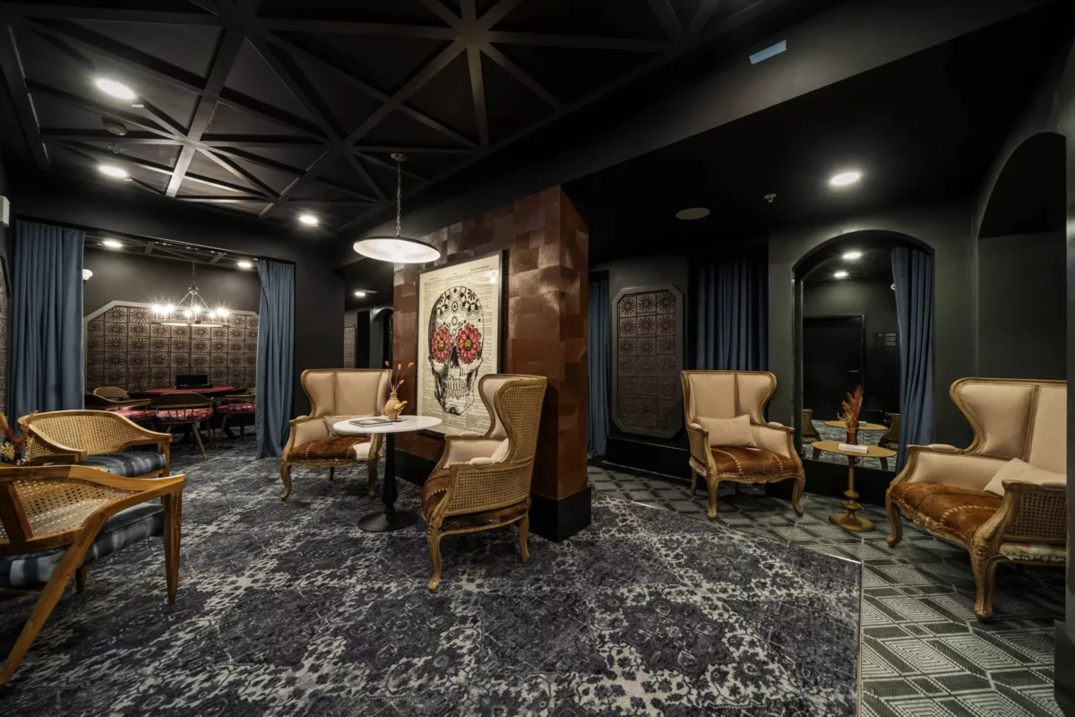 Speakeasy room with dark, lush furniture and fixtures