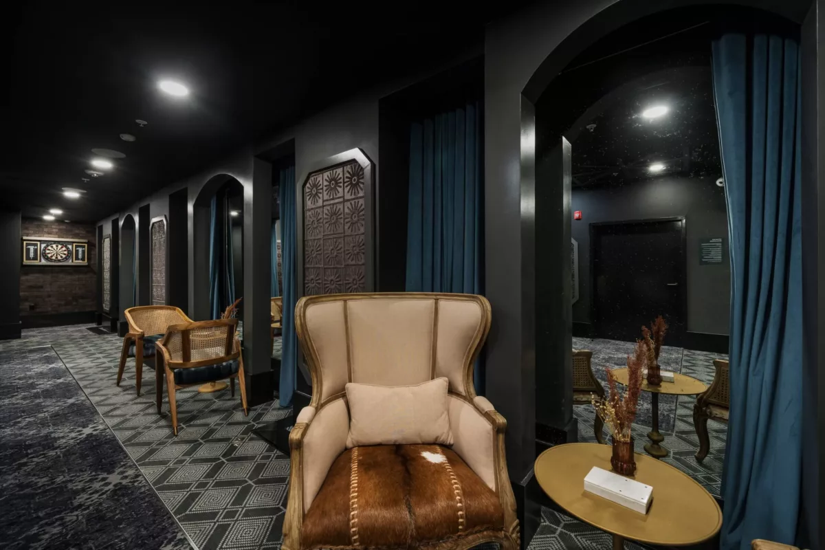 Speakeasy room with dark, lush furniture and fixtures
